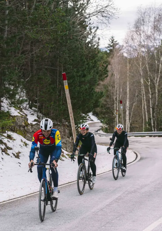 Ciclistas subiendo un puerto con nieve junto a la carretera